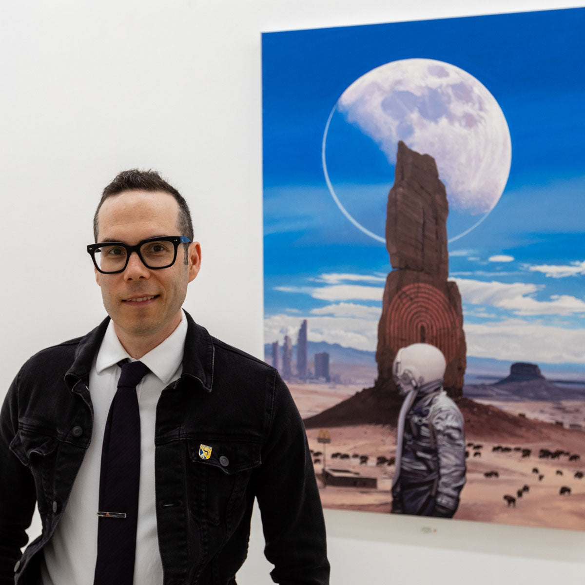 Portrait of the artist Scott Listfield in front of one of his paintings.