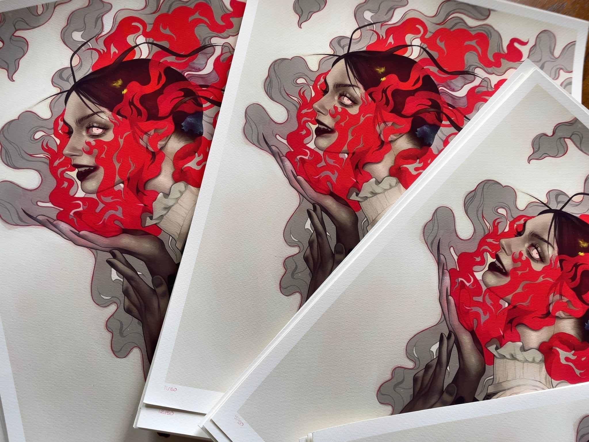 The Smile for Me by Kelsey Beckett showcases mesmerizing designs with multiple prints of a womans face among red and gray swirling abstracts. Each signed, numbered archival pigment print overlaps to highlight detailed design and vivid colors.
