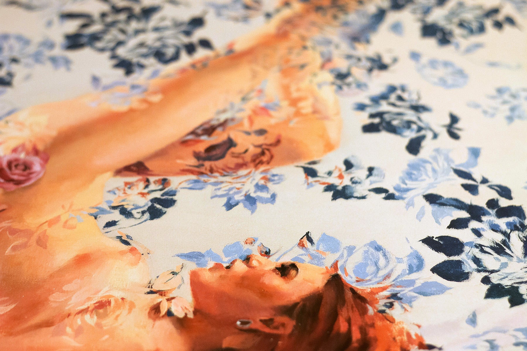 Thisbe by Sergio Lopez depicts a reclining figure with red hair amid blue and white floral patterns. The face and upper body blend seamlessly into the background. This archival pigment print is limited to 40 editions, each signed and numbered for authenticity.