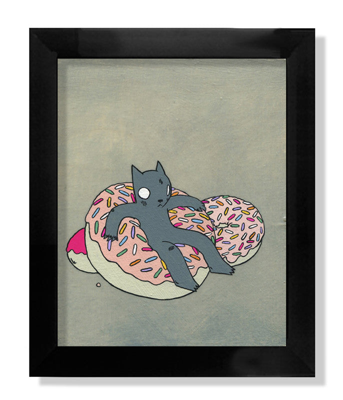 A whimsical illustration titled Donut Cat by Deth P Sun depicts a gray cartoon cat lounging on two pink-frosted, sprinkle-covered donuts encased in a sleek black frame. This delightful piece is a limited edition treasure.