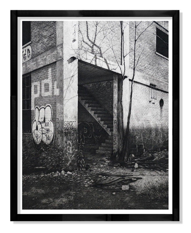 BFFS, a limited edition fine art giclee print by Stephanie Buer, intricately depicts a detailed black and white drawing of an abandoned building with graffiti-covered walls, a staircase, and overgrown vegetation. The artwork is elegantly framed in black.