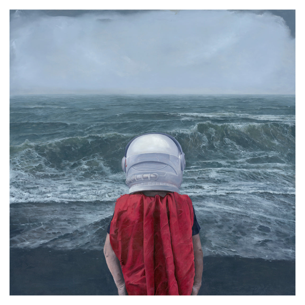 On a cloudy beach with choppy waves, someone in a white astronaut helmet and red cape faces the ocean. The surreal scene resembles Adam Halls A Presence of Wonder, available as an archival pigment print—signed and numbered for authenticity.