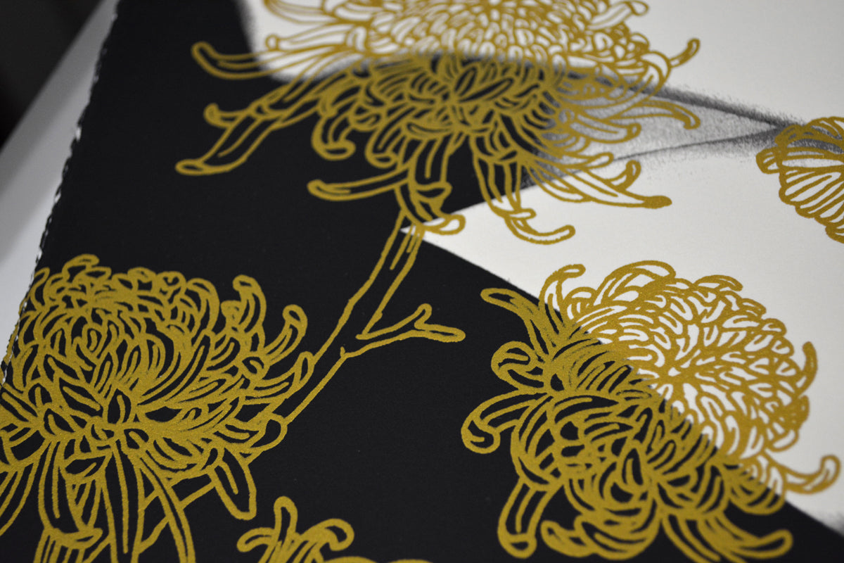 Close-up of The Yellow Passerby & I, a signed limited edition by Tran Nguyen, showcasing intricate gold floral patterns on a black and white surface. The swirling petals create a striking contrast, reminiscent of screenprint artistry.