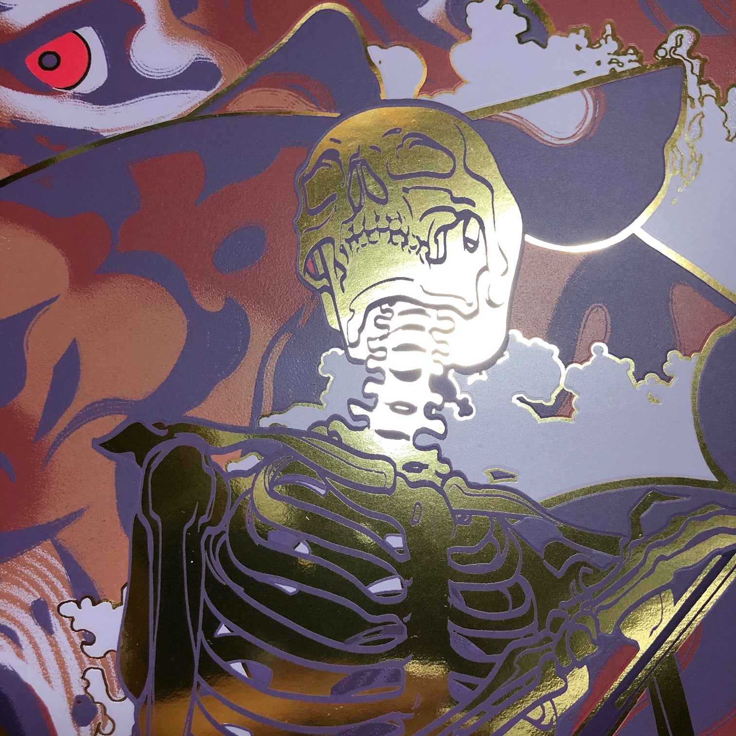 A metallic artwork titled Soothe by JAW Cooper, showcasing a gold skeleton with detailed ribcage and spine against a backdrop of abstract shapes with hints of red and purple, creating a dynamic, surreal screen print-like scene.