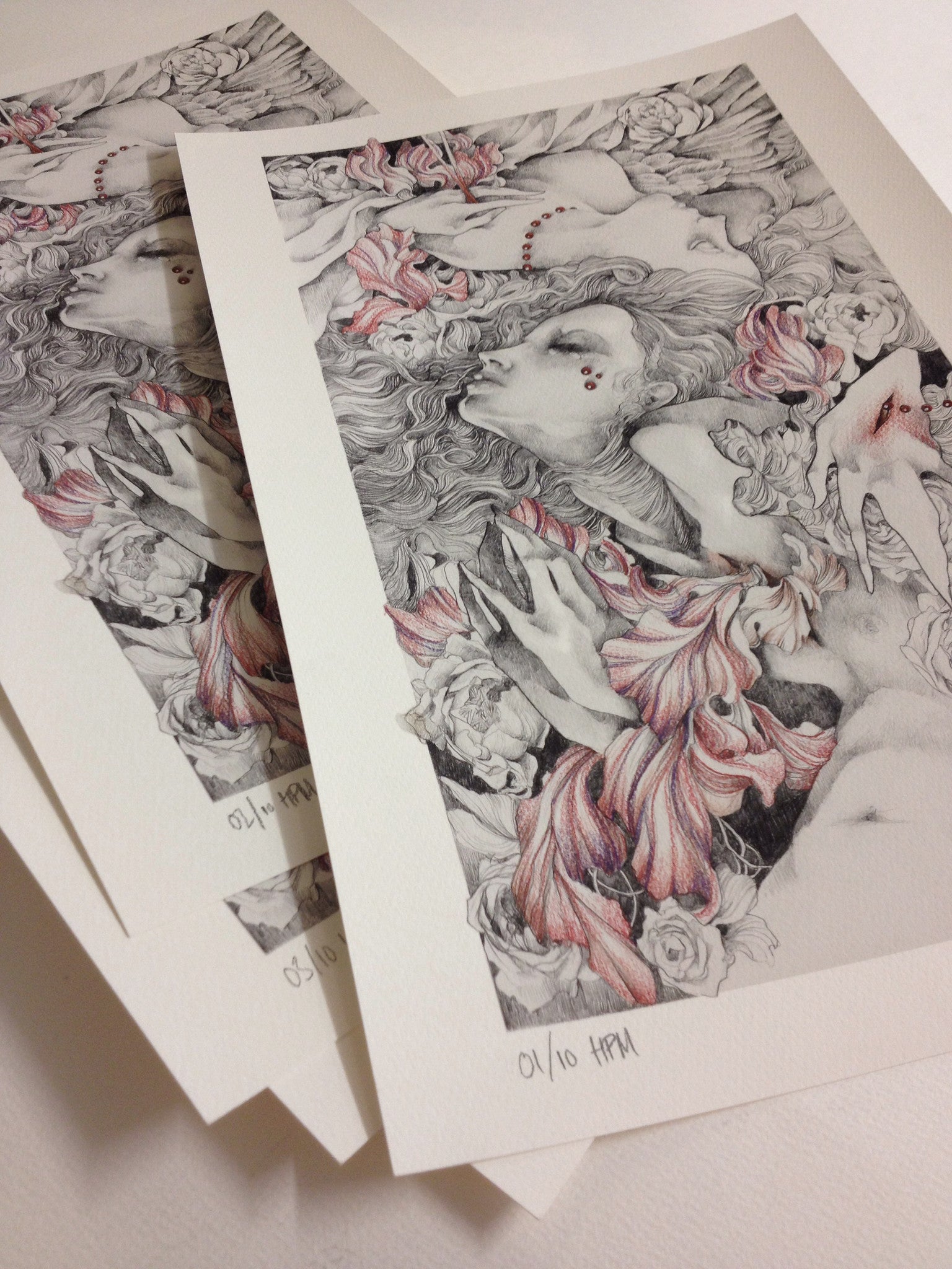 The Safe Passage HPM by Craww is a fine art giclee print, featuring an intricate black and white illustration accented in pink. It showcases a womans face with flowing hair among floral and abstract shapes, hand embellished, signed, and numbered 01/10 HPM at the bottom.
