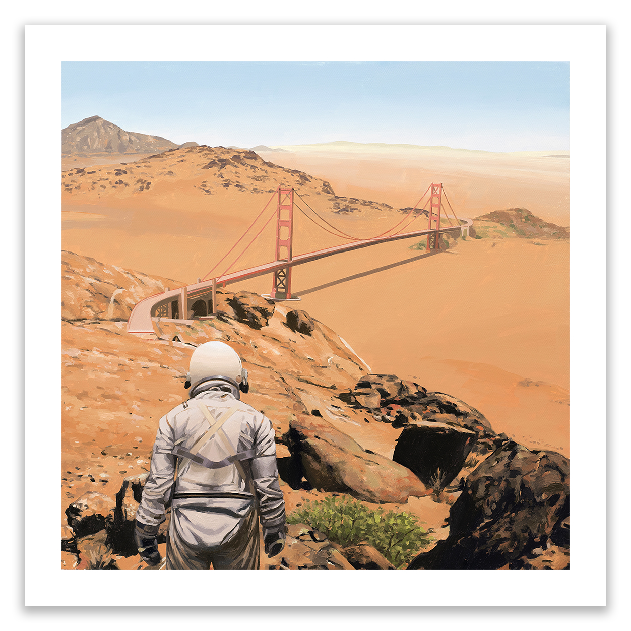 A person in a spacesuit stands on rocky ground, gazing at a bridge resembling the Golden Gate Bridge across an arid landscape. Captured as an archival pigment print by Scott Listfield and titled The Bridge, it features distant mountains under a clear sky.