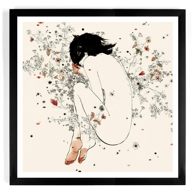 The Cicuta limited edition fine art giclee print by Conrad Roset depicts a person seated with knees to chest, surrounded by delicate flowers and leaves on a soft beige background, framed in black.