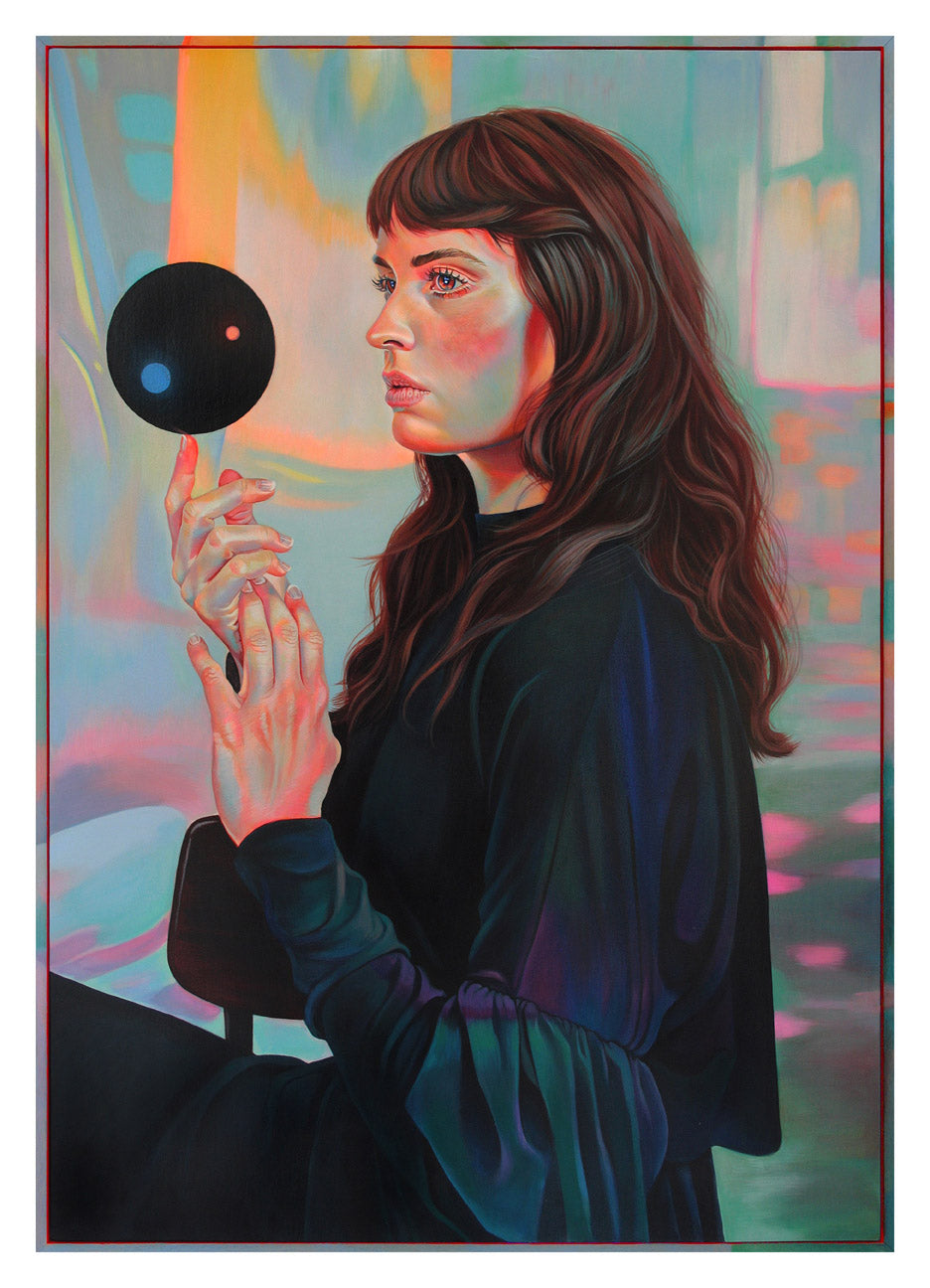 A woman with long hair and a serious expression is seated, holding a black circular object in Power of Three by Martine Johanna. The art bursts with vibrant pink, blue, and orange colors against an abstract, dreamlike backdrop reminiscent of an archival pigment print.