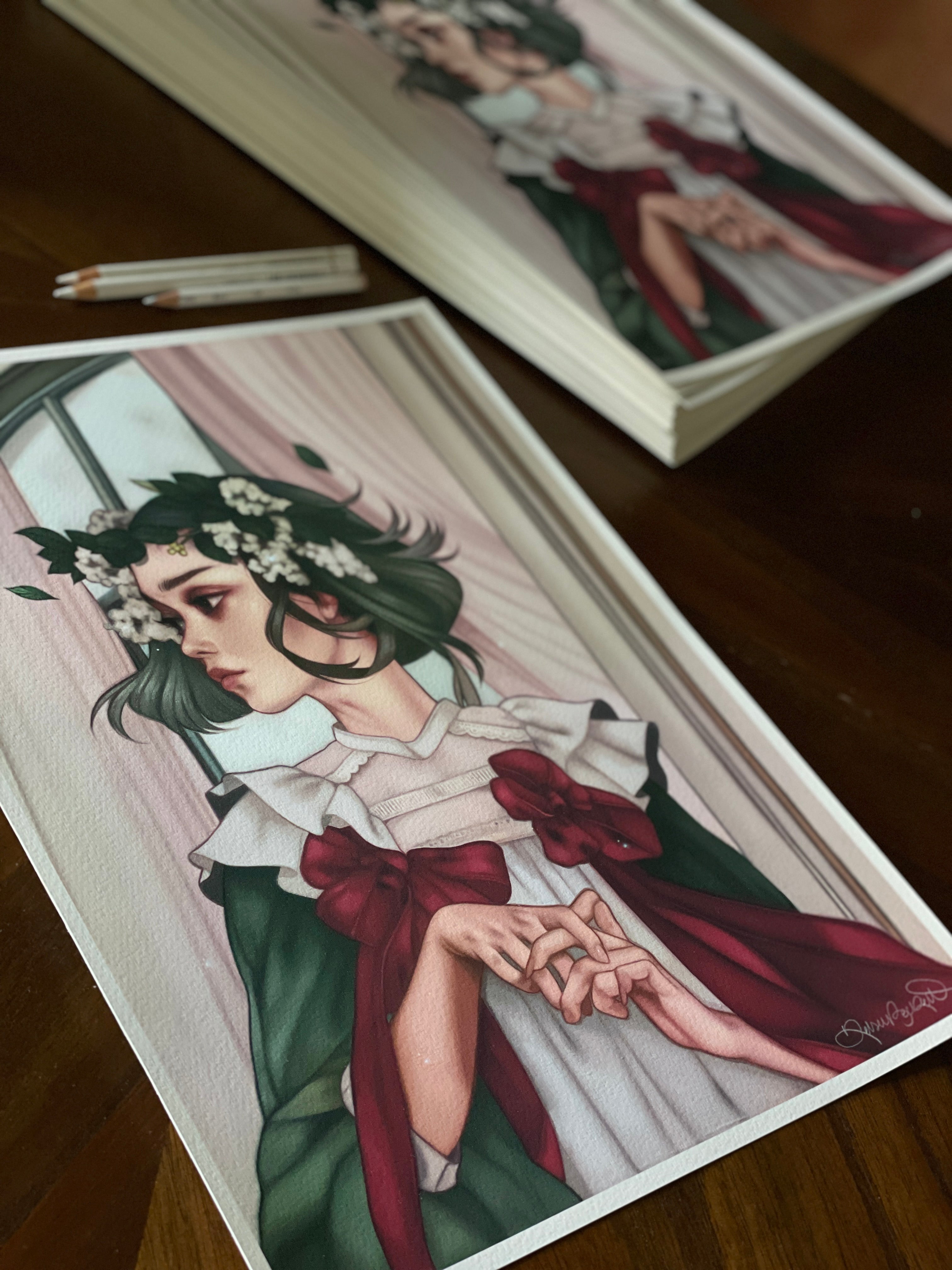 The limited edition Another Last Time by Kelsey Beckett features a digital artwork of a person with short green hair in a green and white floral outfit. The archival pigment prints are thoughtfully posed on a wooden table, with a pencil lying beside them.