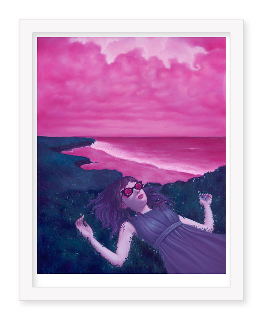 A person with long hair and sunglasses lies on grass near a cliff, gazing at a pink ocean beneath cloudy skies. The vibrant pinks and purples resemble the dreamy atmosphere of Syd Bees Breathing Spell.