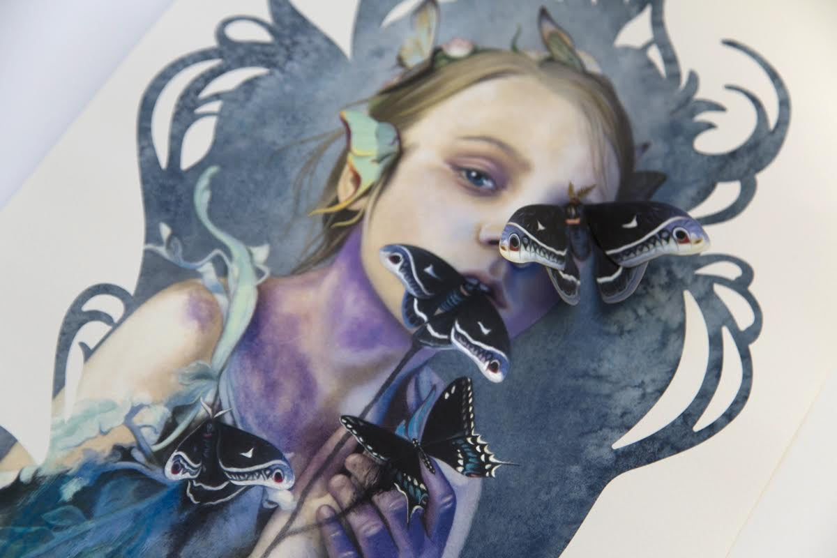 The art piece Words Unspoken by Redd Walitzki depicts a girl with ethereal features and a flower, adorned with black, white, and purple paper butterfly sculptures. Swirling patterns blend into her hair and attire, creating a dreamlike atmosphere reminiscent of Walitzkis distinctive style.
