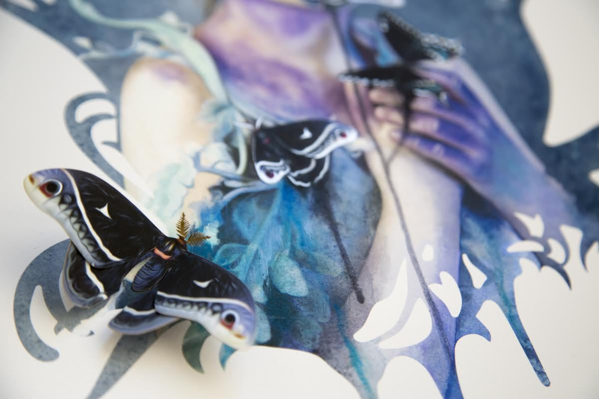 Words Unspoken by Redd Walitzki is a mixed media piece depicting a person with paper butterfly sculptures and a real 3D butterfly. Hand embellished in blue and purple, it harmoniously blends realistic and abstract elements with intricate details.