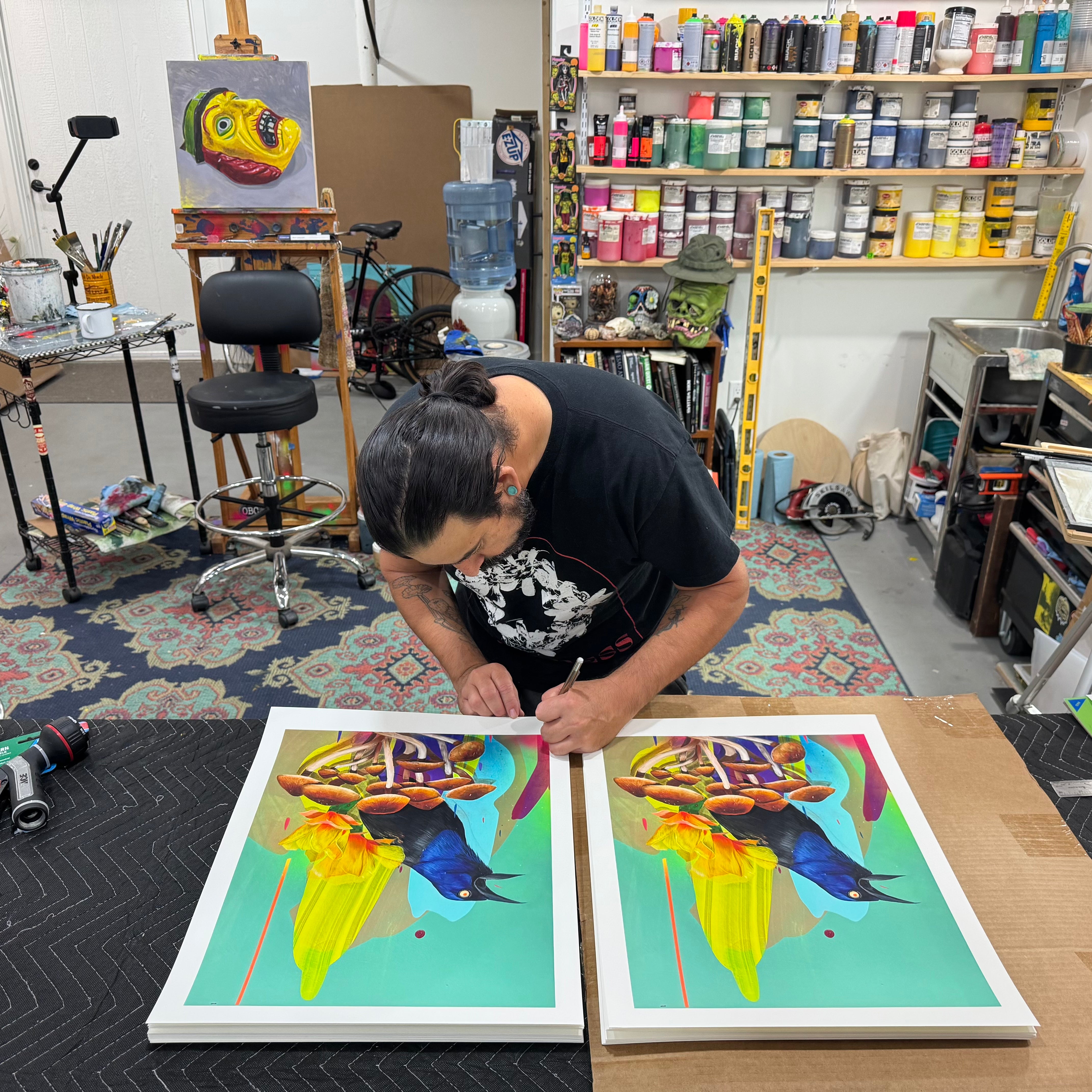 Artist working on artwork in a studio with art supplies around