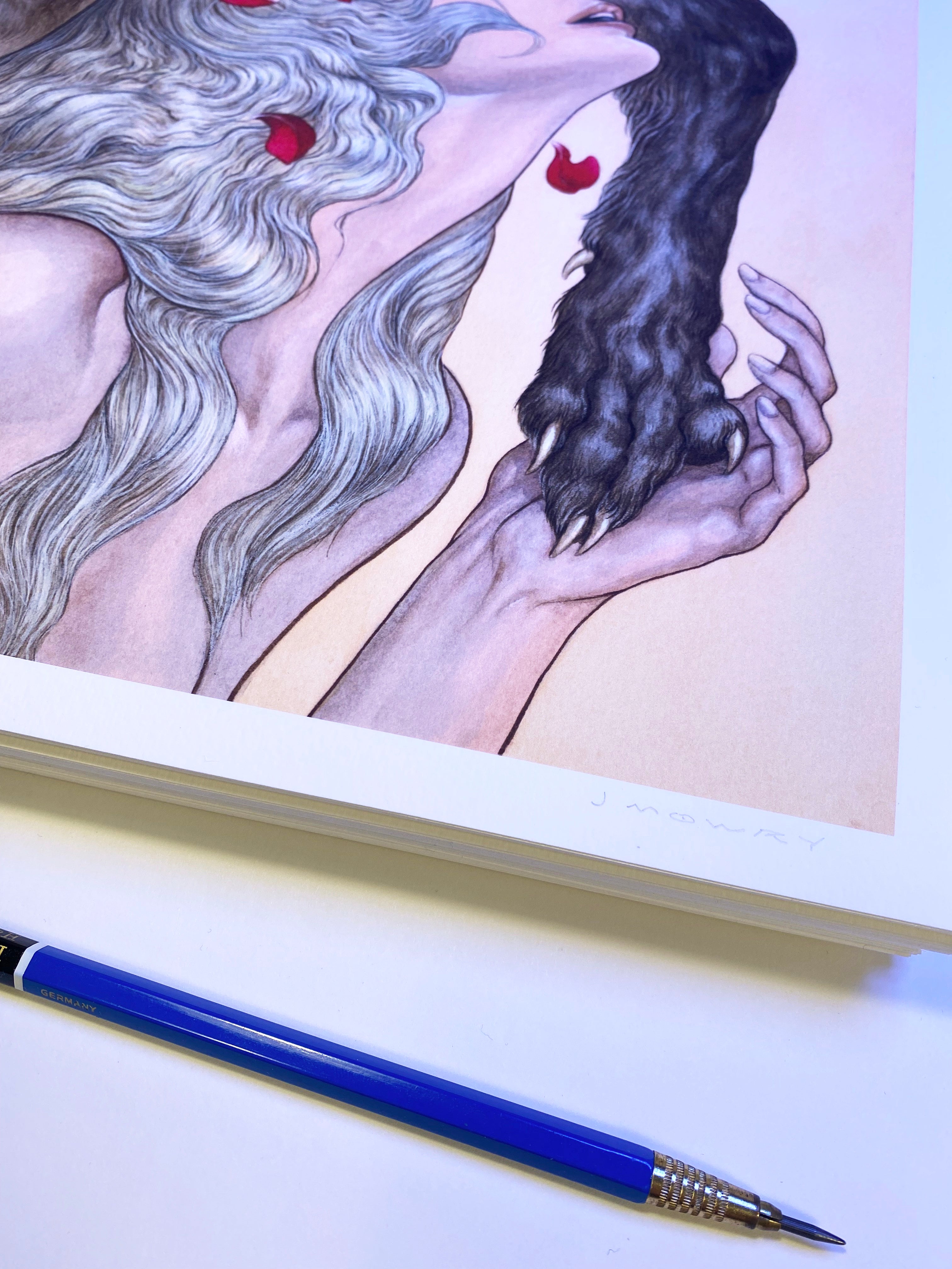 Blessings from the Maw, an art print by Jason Mowry, depicts two figures with long wavy hair—one light with red accents and one dark. A blue mechanical pencil on a white surface foregrounds this museum-quality archival pigment print.