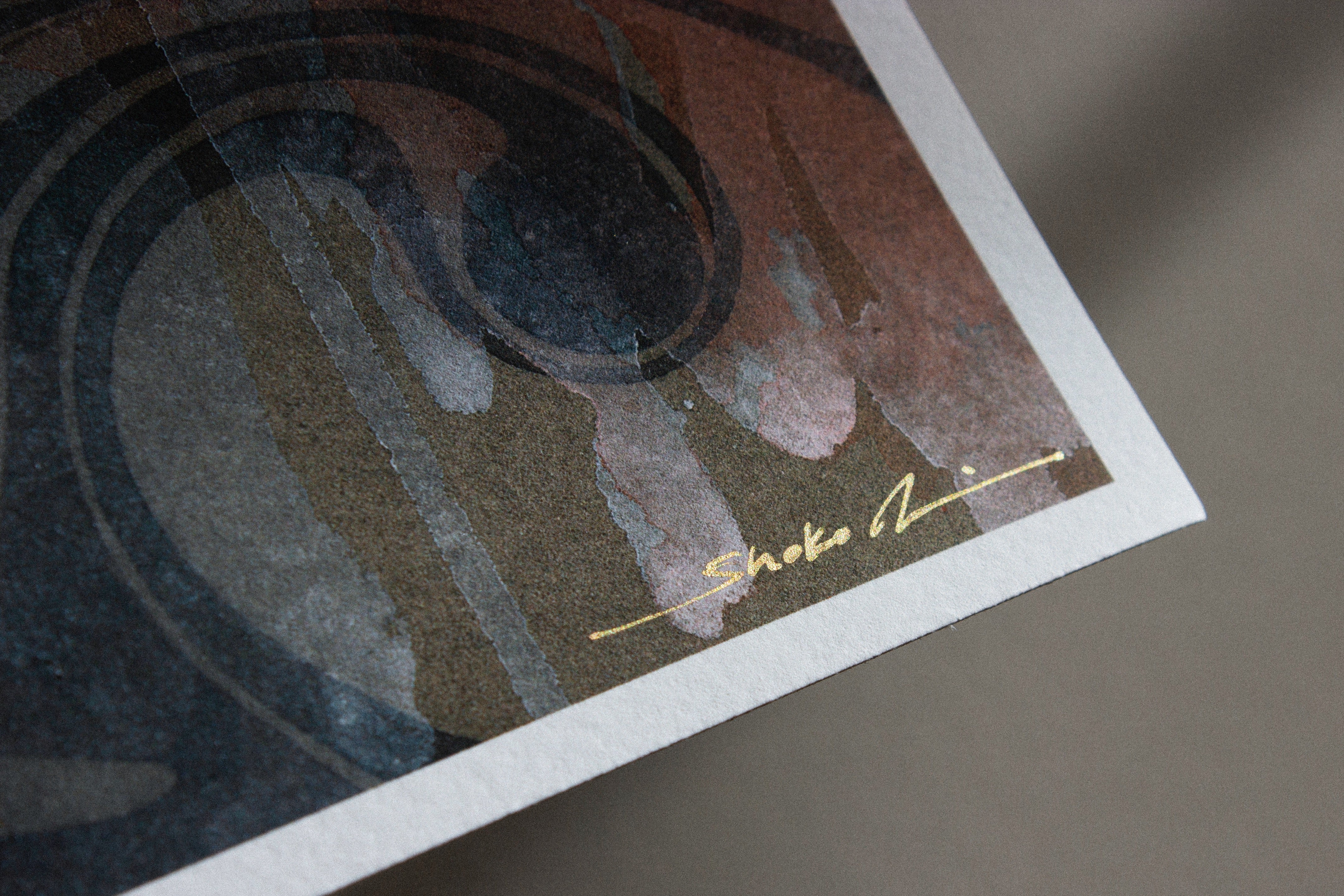 Close-up of an abstract painting with swirling dark colors, featuring a gold signature that reads Shoko M. in the bottom right corner. The image highlights texture and brushstrokes, reminiscent of Meguri, an archival pigment print by Shoko Ishida.