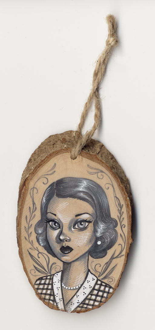 The Untitled #1 by Sandi Calistro features a black and white illustration of a woman with short, wavy hair wearing a patterned top. Decorative leaves surround her acrylic-painted wood ornament, complete with a rustic twine loop for hanging.