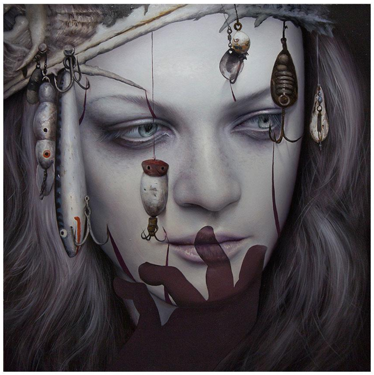 A person with a pale face, long hair, and a lure-adorned hat exudes an aura reminiscent of Dan Quintana’s style. Their downward gaze and shadowed hand on their face amplify the drama of Barracuda, an archival pigment print by Dan Quintana.