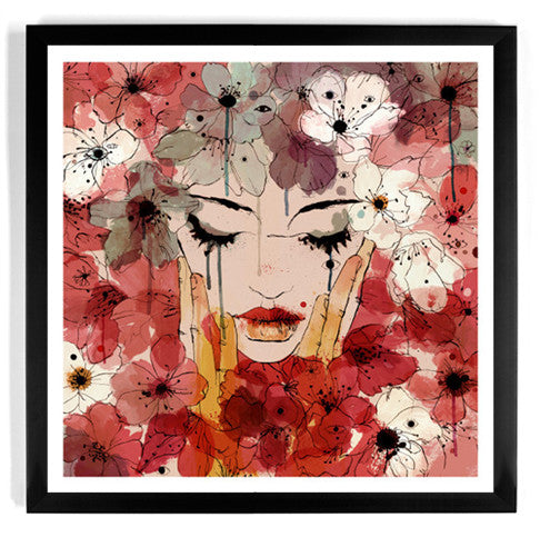 The limited edition framed fine art giclee print Dhalia by Conrad Roset features a dreamy composition of a womans face with closed eyes, hands on cheeks, and her hair transforming into red, white, and pink watercolor flowers.