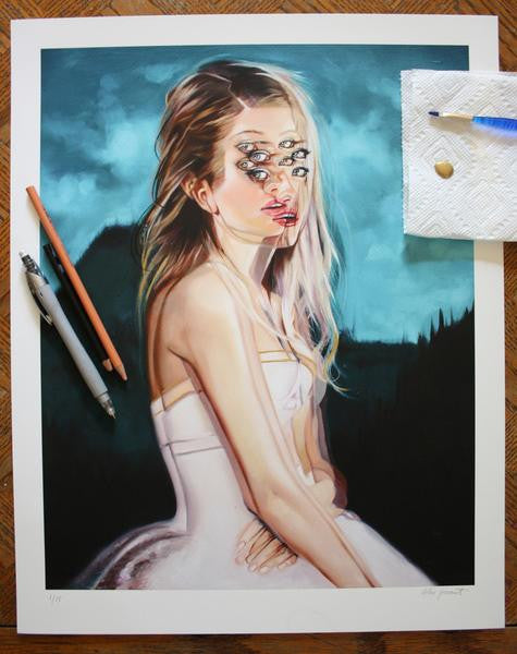 Summer Dreams Regular Edition by Alex Garant is a fine art giclee print of a surreal portrait featuring a woman in a white dress with overlapping eyes and lips, placed on a wooden surface among pencils, pens, and paintbrushes.
