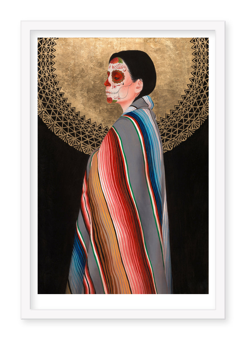 A woman in a colorful striped shawl stands in profile against Sol de Oro by Sylvia Ji, an ornate golden circle with intricate patterns. Her face is painted with traditional Day of the Dead skull designs, showcasing Sylvia Jis masterful cultural and artistic blend in her fine art prints.