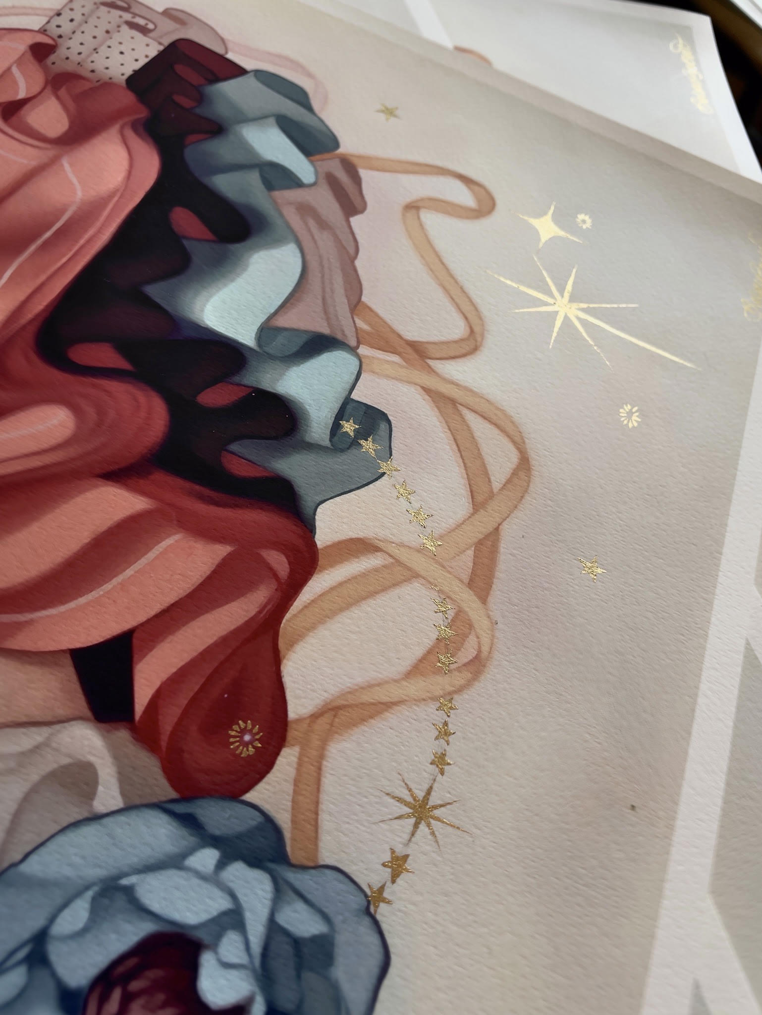 Kelsey Becketts Abundance is a hand-embellished abstract artwork with wavy layers in red, black, blue, and beige, adorned with delicate gold stars and starbursts for a celestial touch.