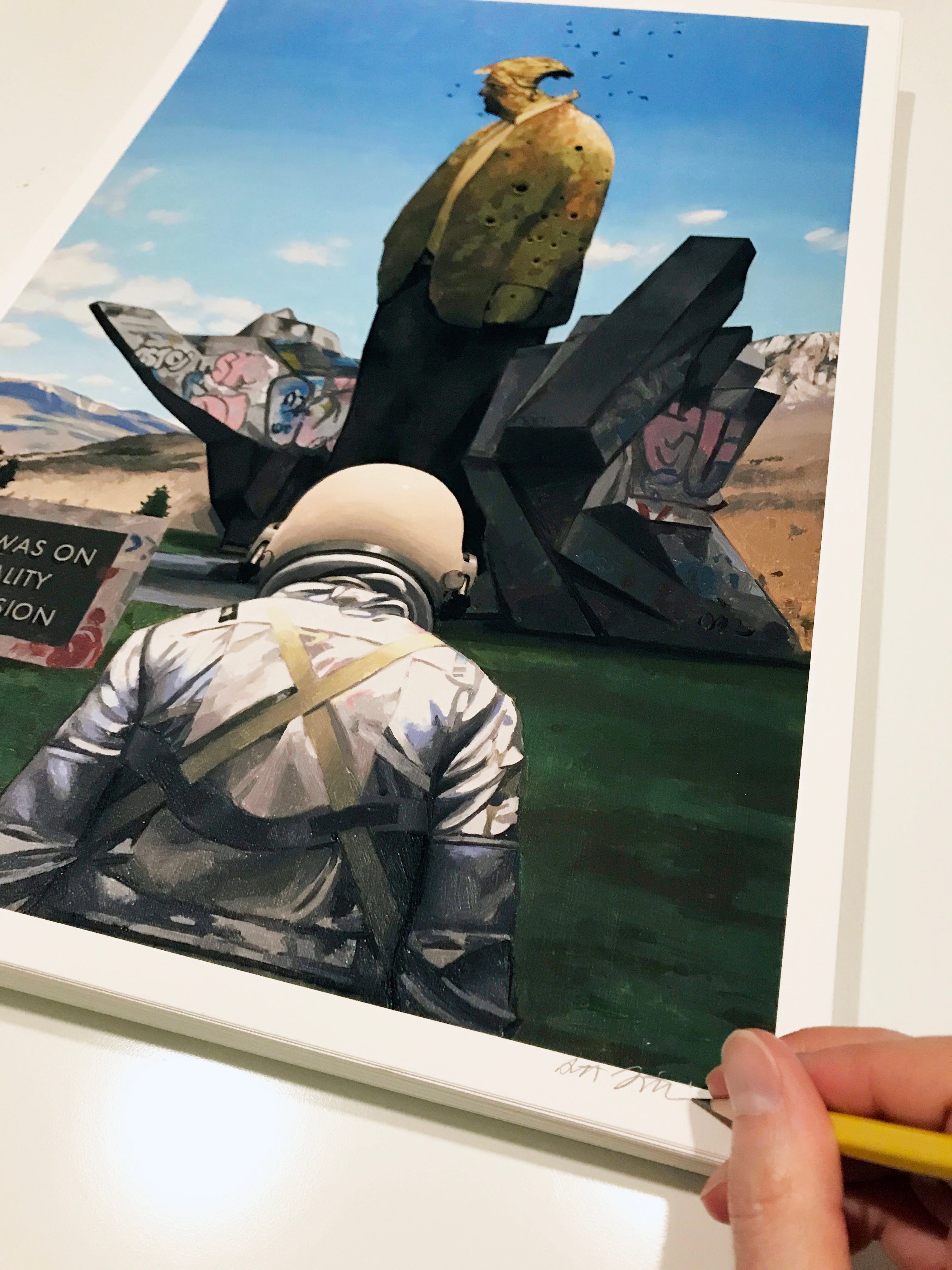 In Reality Television by Scott Listfield, a spaceman stands before an outdoor sculpture with a yellow-clad figure, adorned with graffiti and a signed hand in the foreground; mountains and clouds complete the archival pigment print scene.